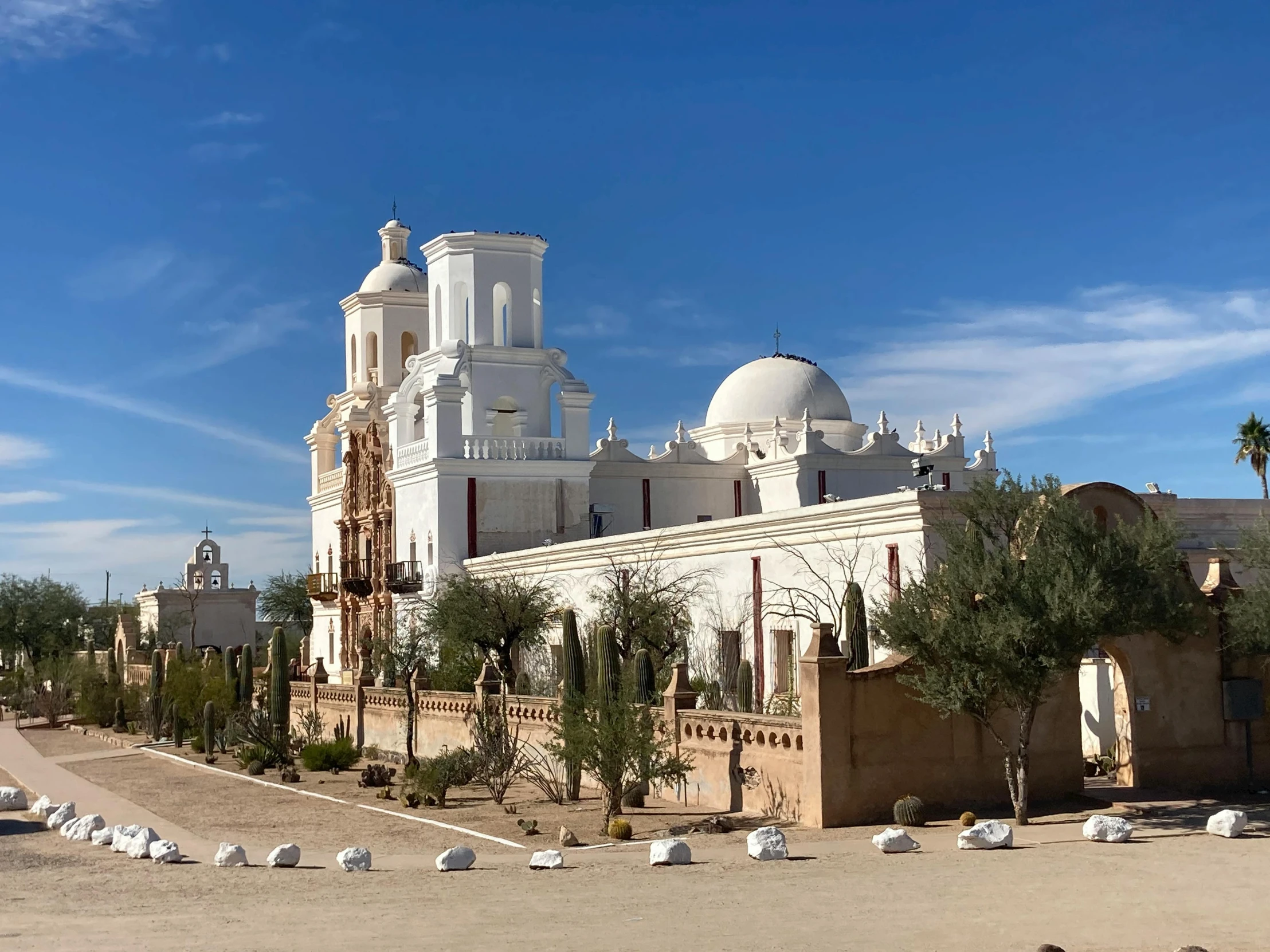 a big church sits among some trees and bushes