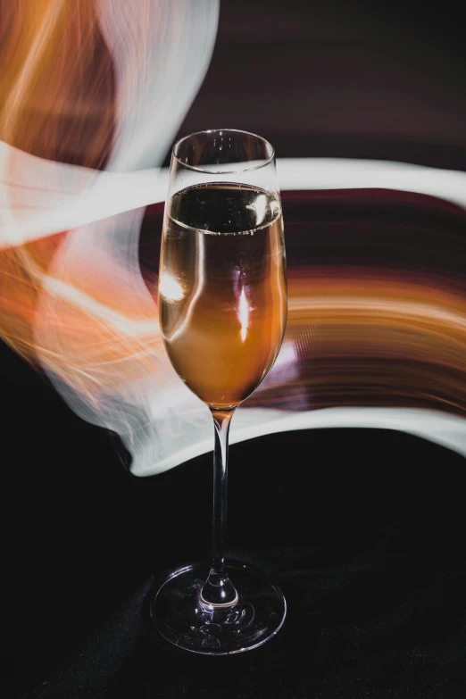 a glass of wine is shown against an abstract background