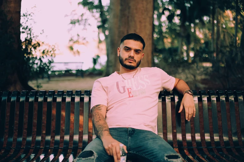 a man sitting on a bench with his legs crossed