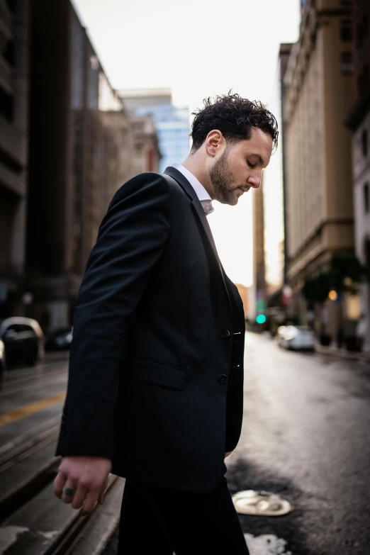 a man in a suit and tie stands in front of a city street