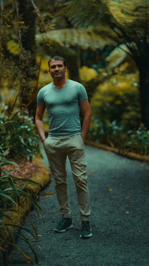 a man is standing in the middle of a path in the woods