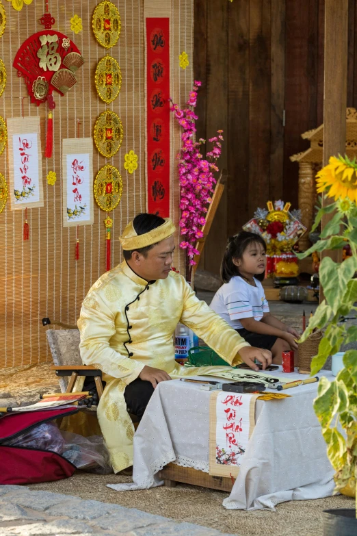 an asian couple in traditional clothing playing drums