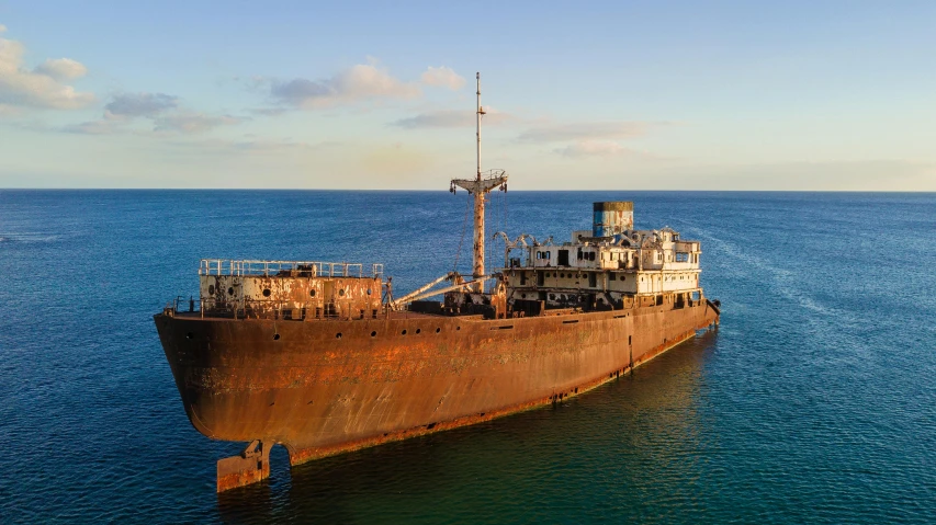 a rusted ship floating in a body of water