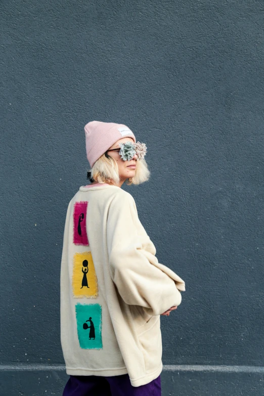 a woman is wearing a long cardigan with a colorful graphic