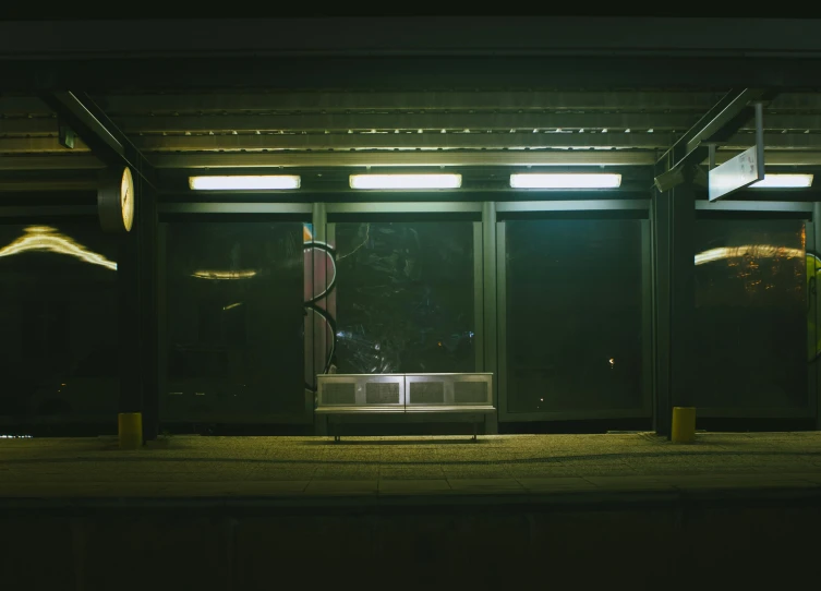 an empty bench in a dark building under lights