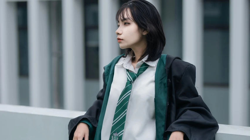 the young woman in the suit and tie is standing on the ledge