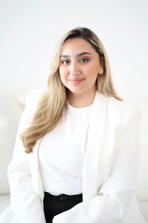 a woman posing for a portrait in a white suit