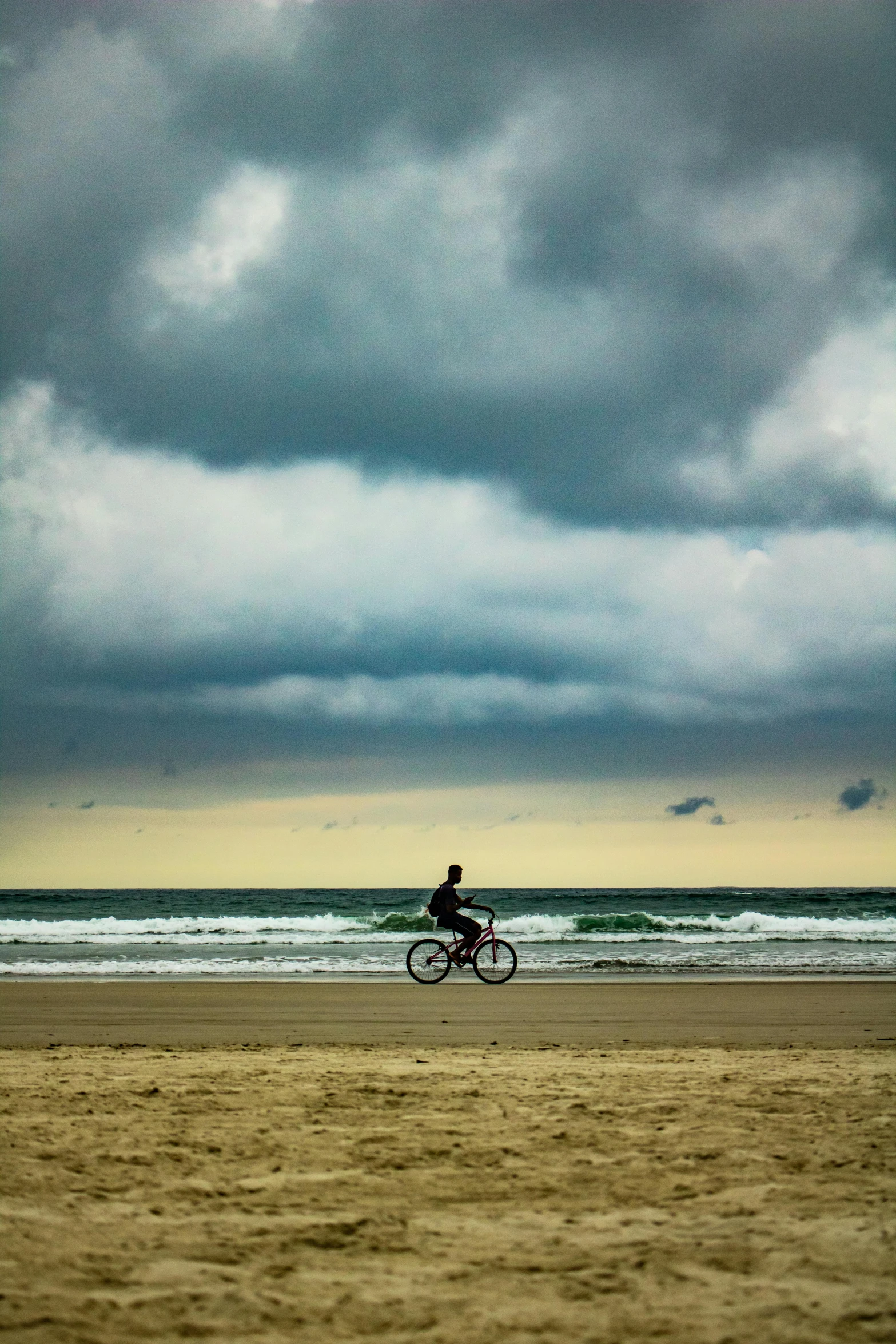 a man on a bike riding by the water