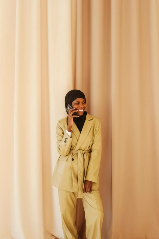 a woman poses for the camera in a beige suit