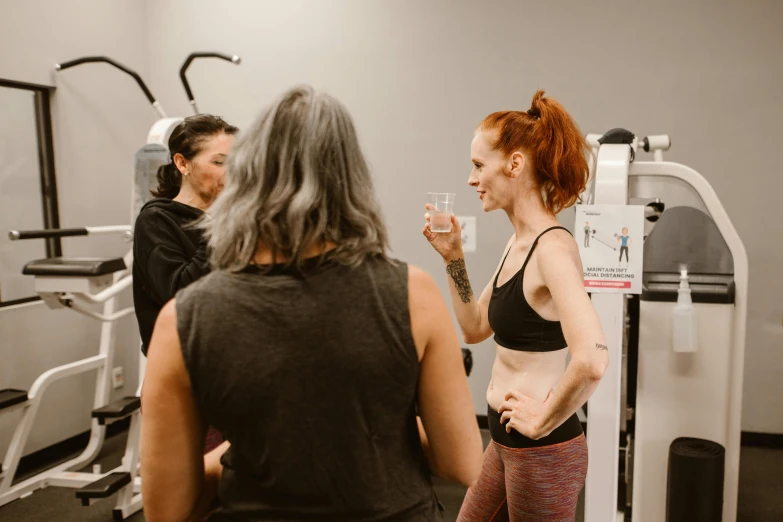 a woman talking to her friend at the gym