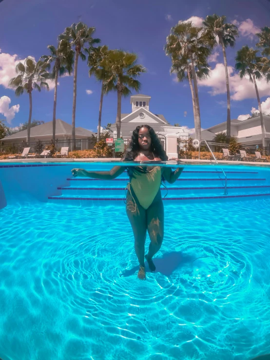 an artistic image of a woman in a swim suit and her back turned is visible