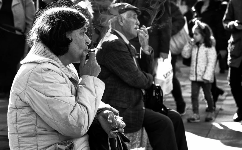 a woman is sitting down smoking a cigarette