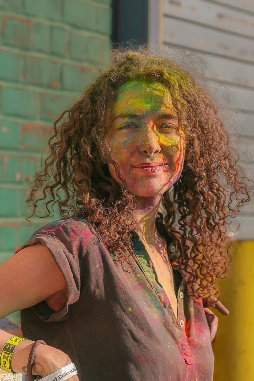 a smiling child holds onto her arms with the paint