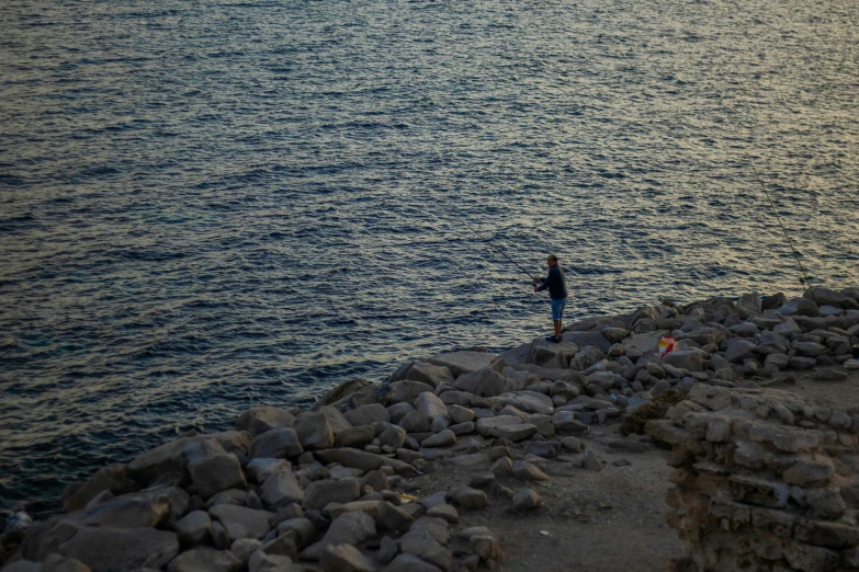 a lone person standing in the sun over the water