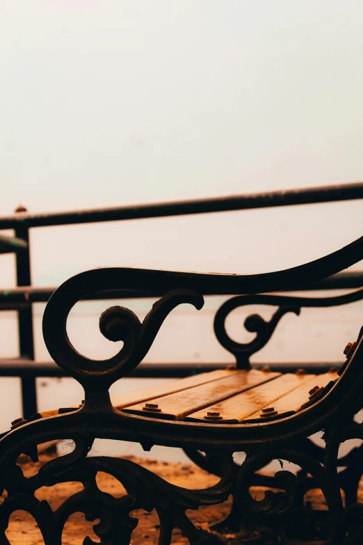 close up po of an antique wooden bench near the water