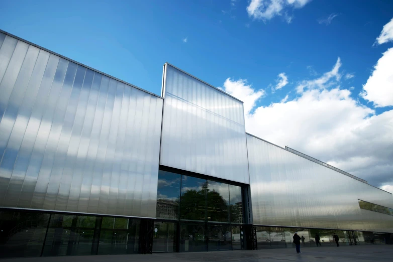 a glassy building with a person walking in front