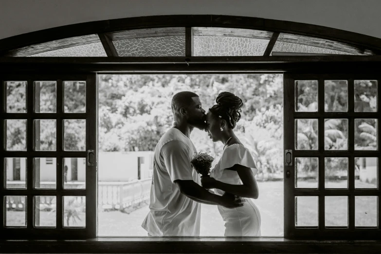 a man and woman that are kissing in front of an open door