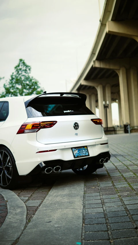 a white car parked by a highway on a sidewalk