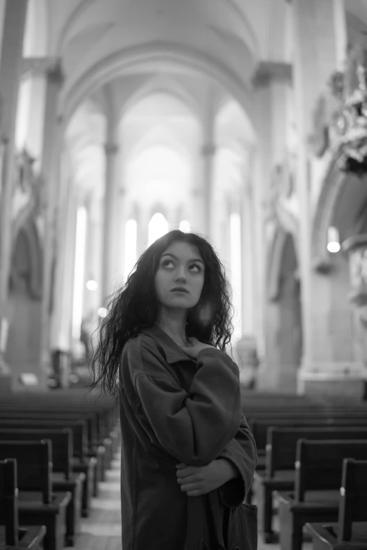 a young woman is sitting in the pew of a church