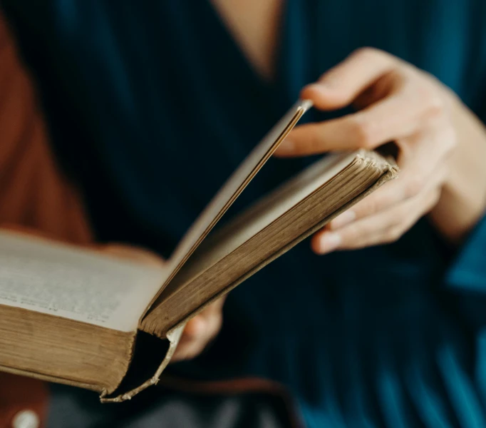 a person holding a open book in their hand