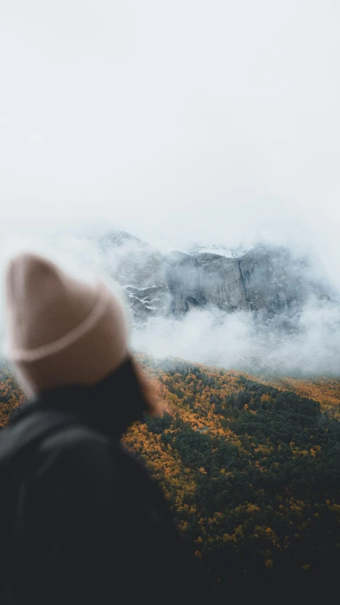 a person with a hat looking at the clouds