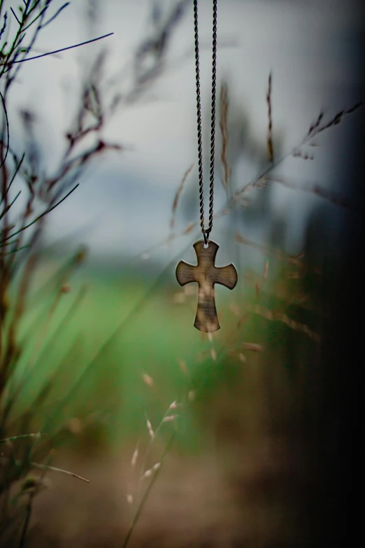 a metal cross hanging on a chain