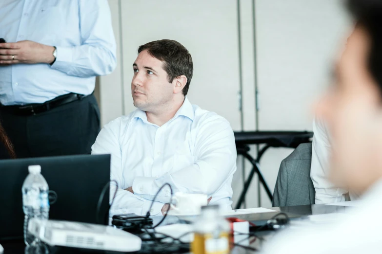 man in white shirt and gray pants at table