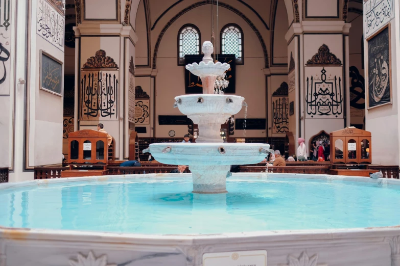 the large water fountain has flowers in it