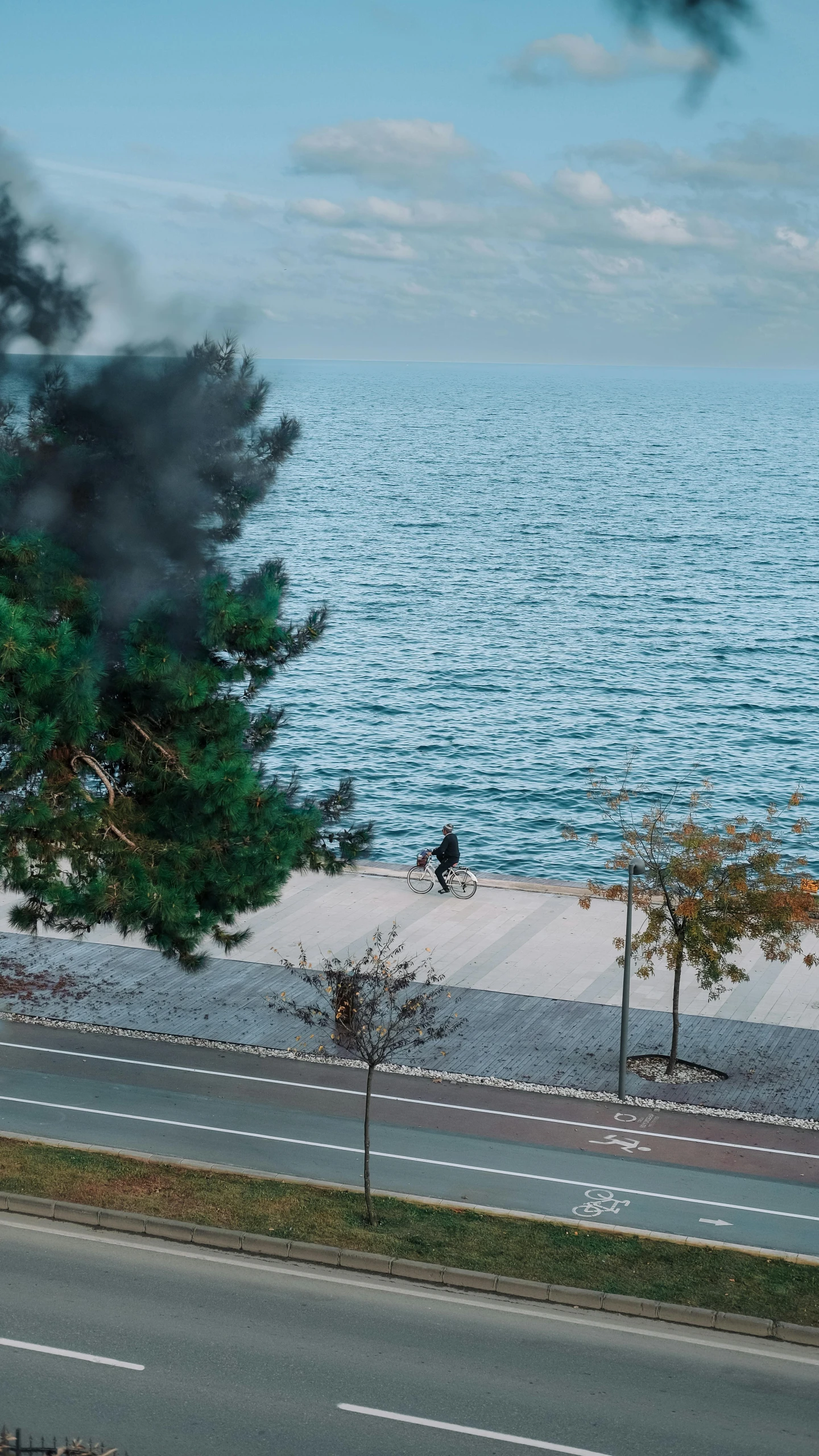 two people stand at a road near the ocean