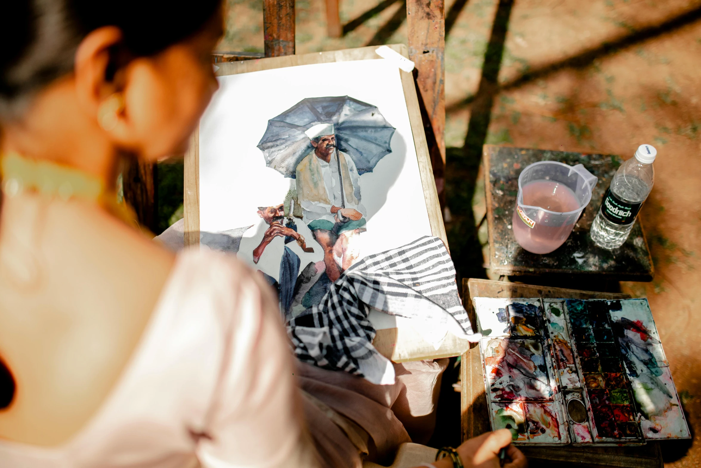 a woman sitting at a table in front of a painting