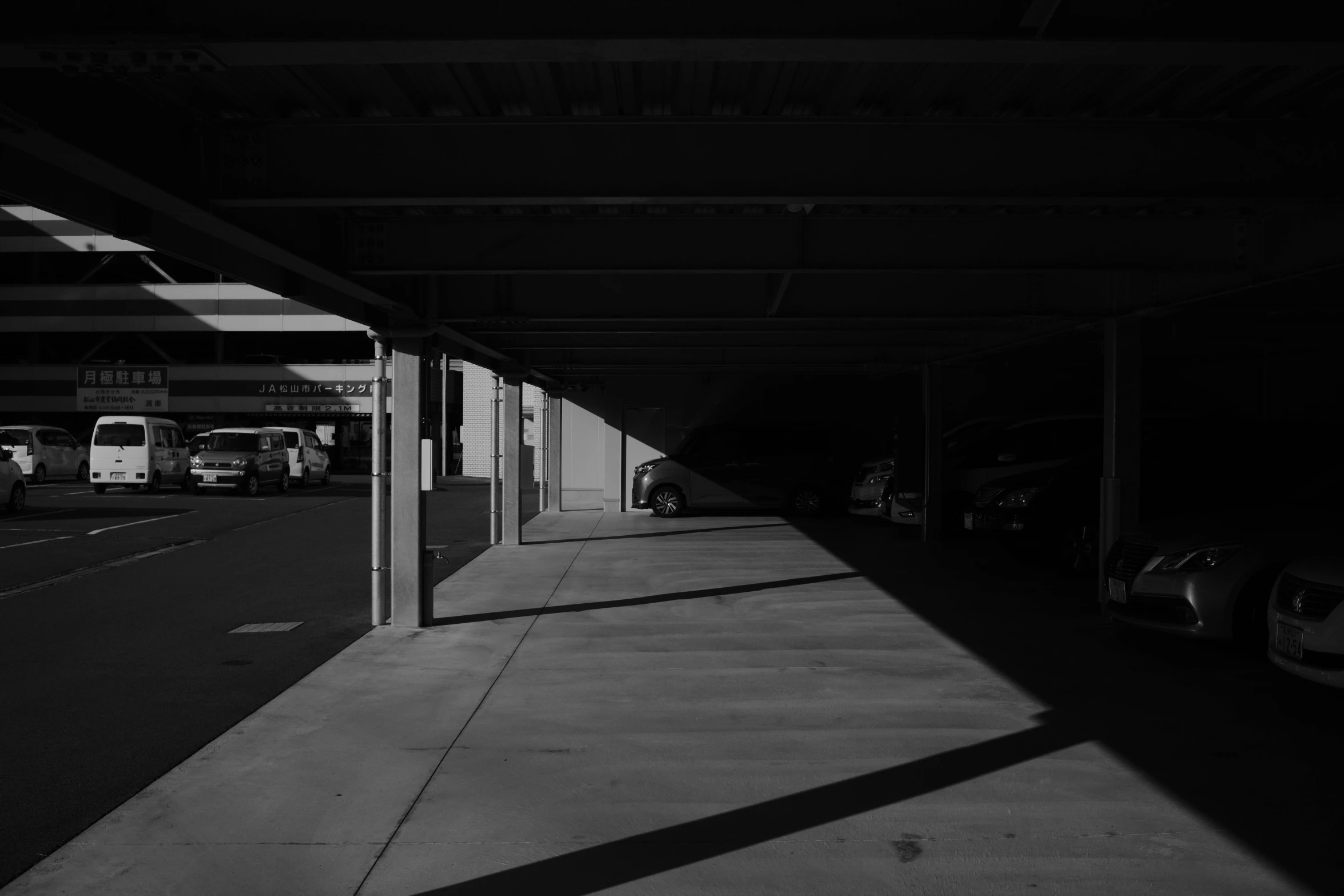 cars are parked along the wall between two buildings