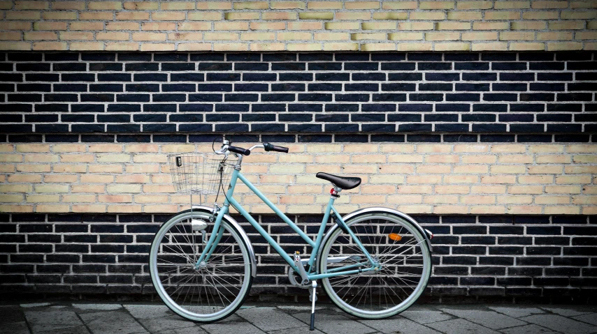 a bike leans against the brick wall