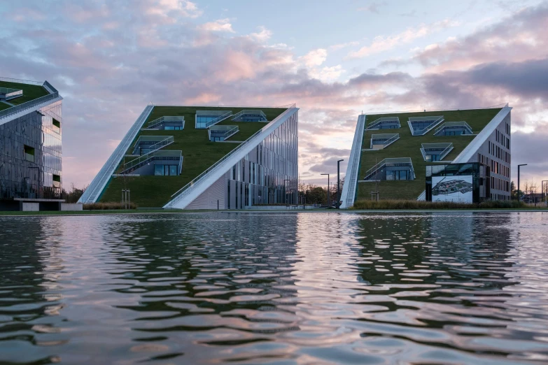 modern building by water with grassy roofline