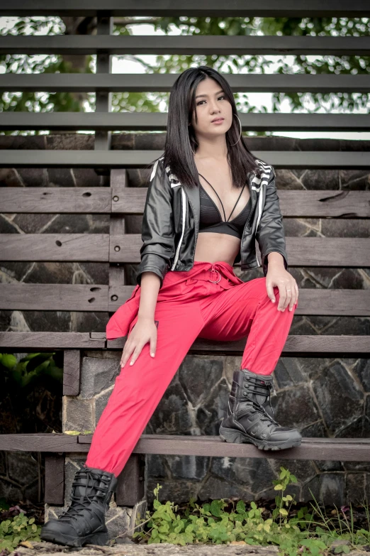 a woman wearing high boots sits on a bench