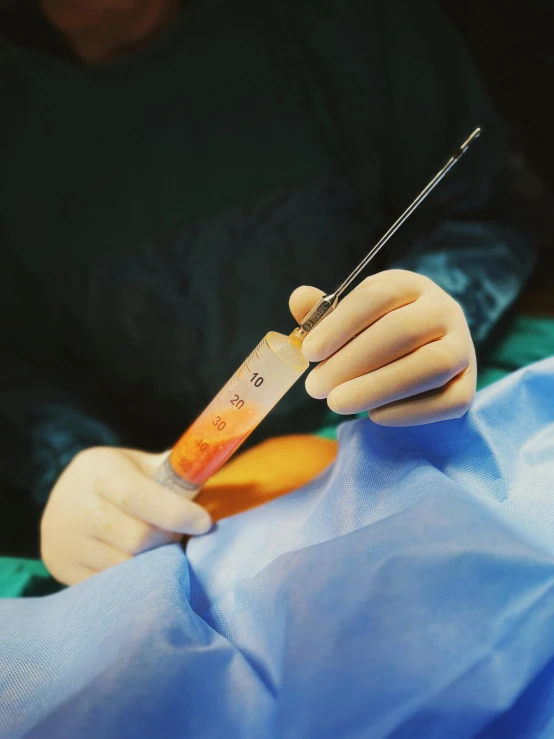 hands are using a needle to perform medical 