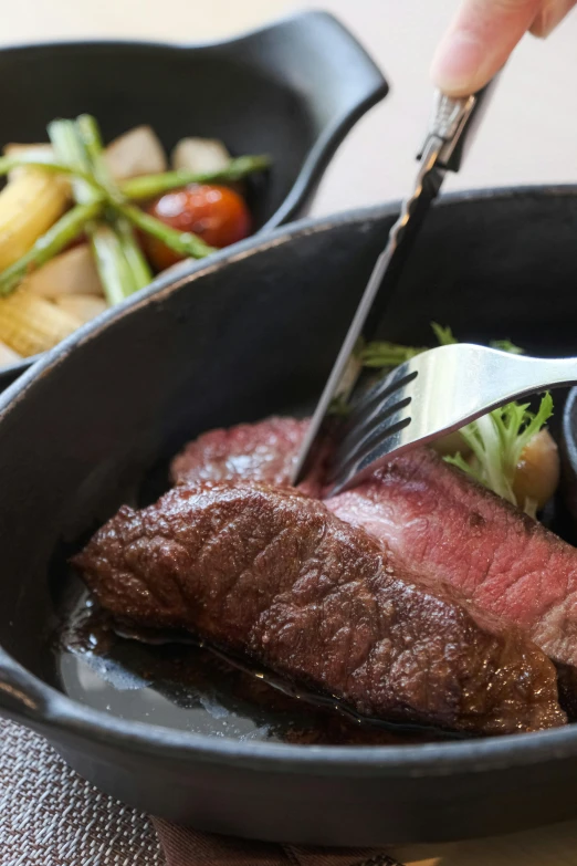 the beef is in a black pan with vegetables