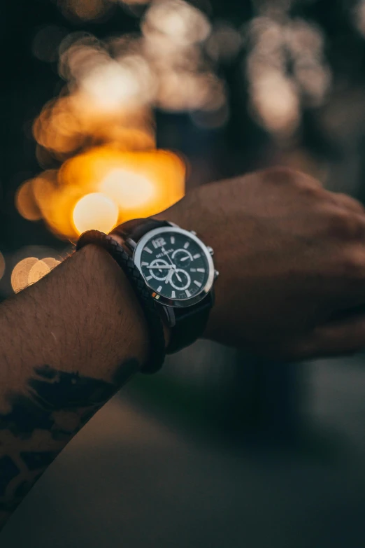 person wearing watch with blurred image in background