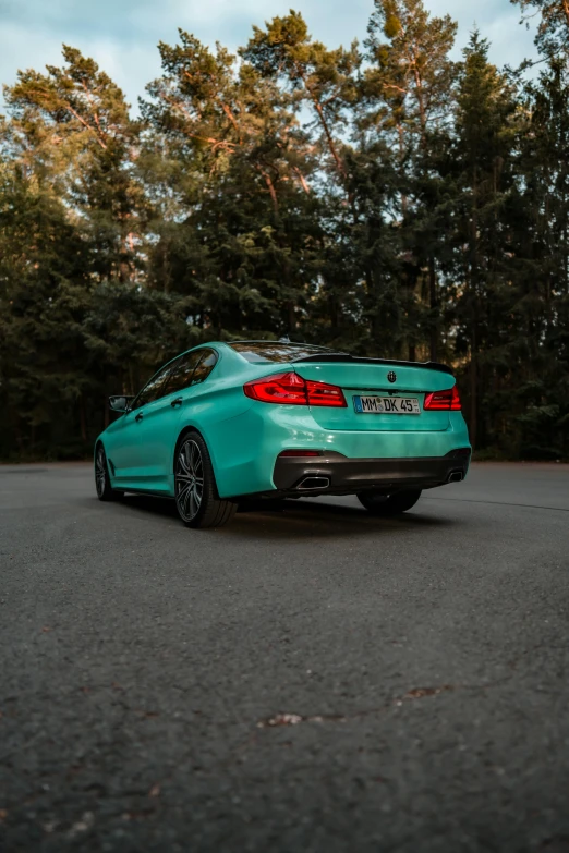 a blue bmw coupe is parked on the road