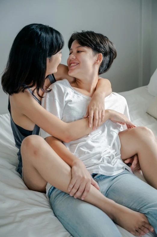 two women sitting in a bed sharing a moment