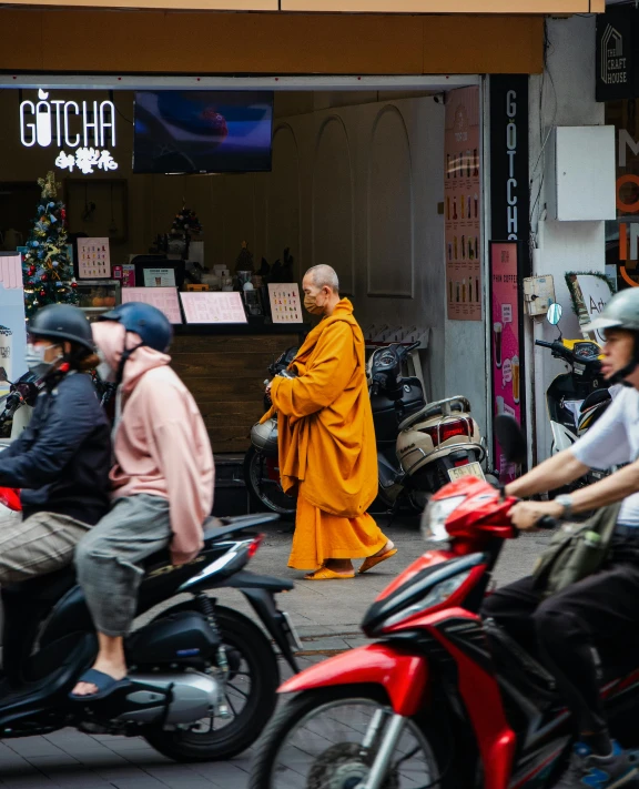 a man with a yellow robe riding a motorcycle