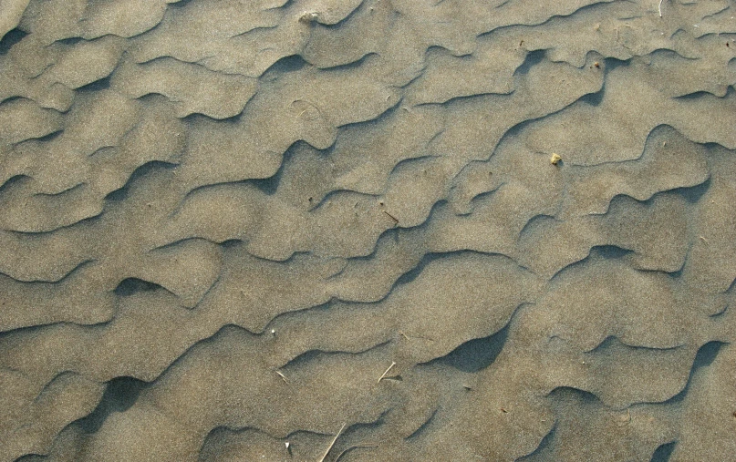 an image of sand with waves in the background