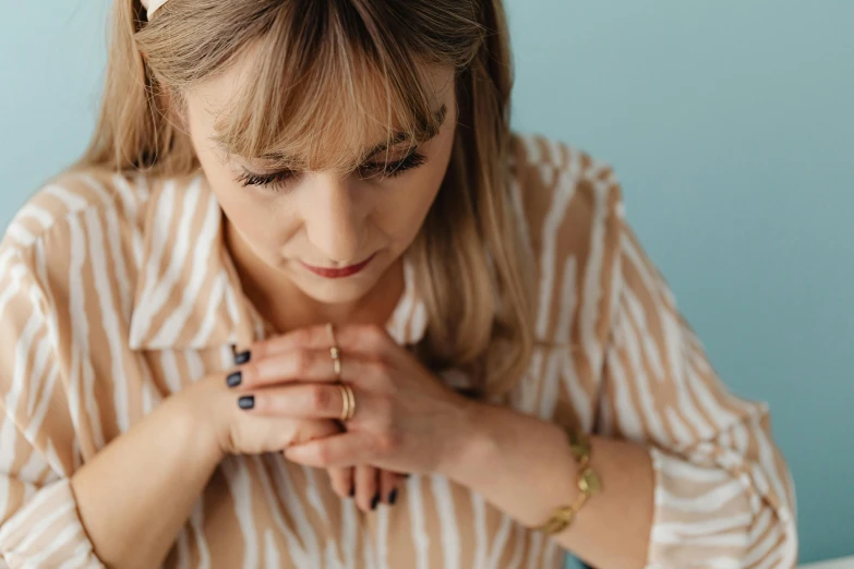 a young lady that is praying her hands