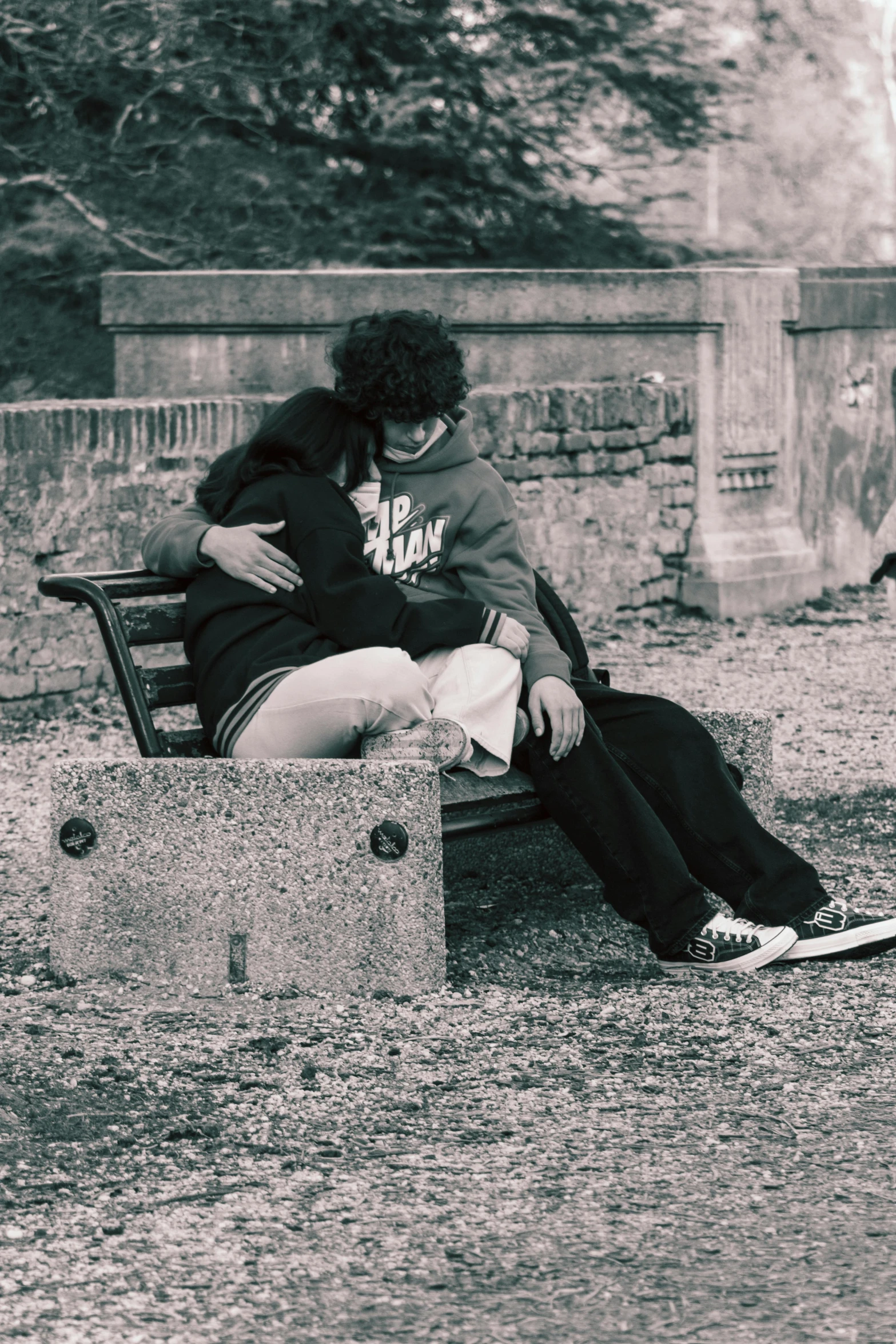 a black and white po of two people sitting on a bench