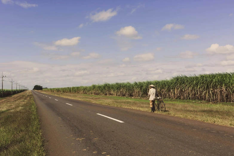 the man is on his bicycle and riding down the road