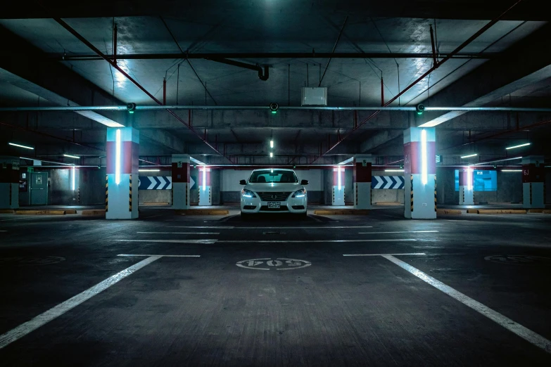 an empty car park is at the center of an otherwise black parking garage