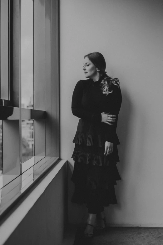 a woman is leaning against a window sill