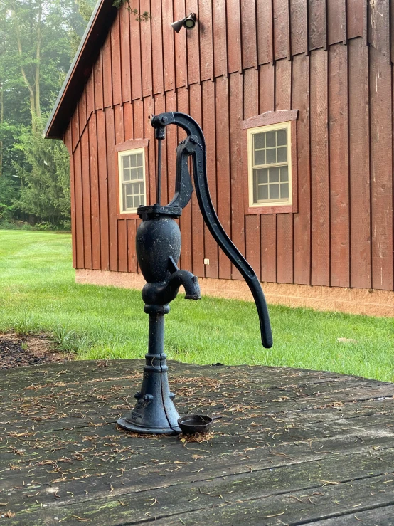 a black coffee pot stands on top of an iron cup