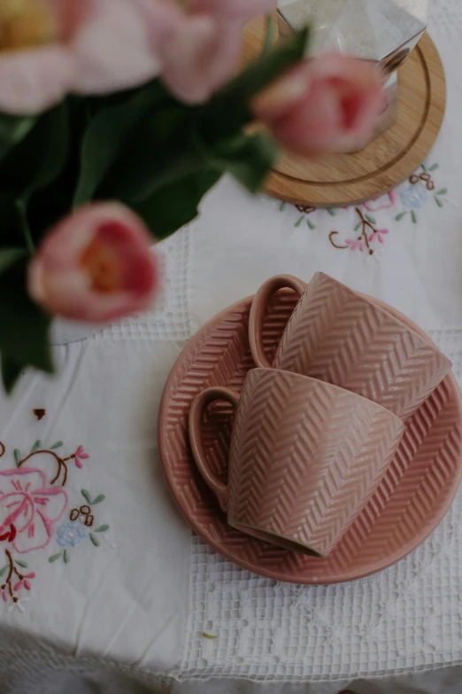 a table has three cups and saucers on it