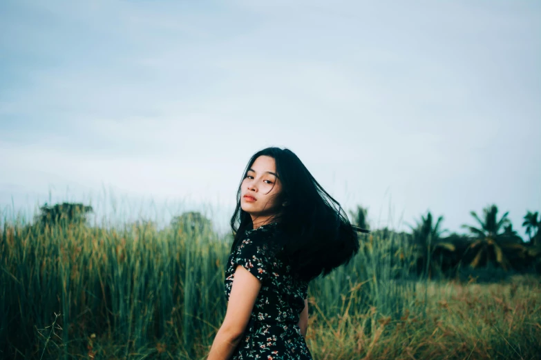 a woman in a field is staring forward