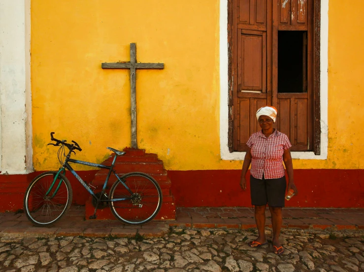 a woman standing in front of a yellow building